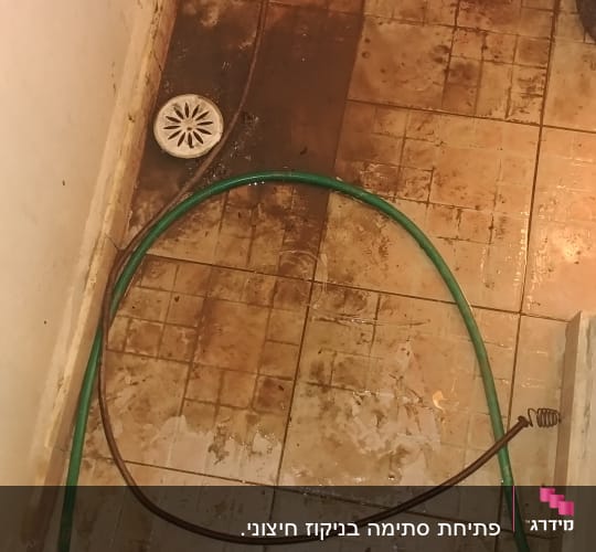 צינור ירוק על רצפה רטובה עם ניקוז